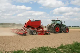 Červený secí stroj Kverneland u-drill plus při práci na poli