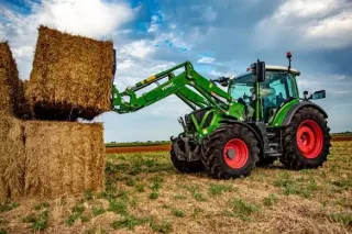 Nakladač John Deere zvedá balík slámy