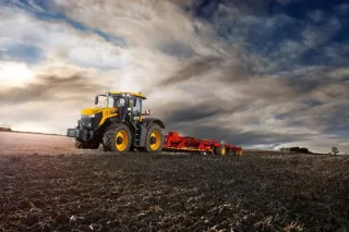 Žlutý traktor JCB Fastrac iCON 8000 při práci na poli