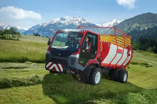 Červený transportér Lindner Unitrac 122 LDrive na louce