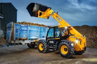 Žlutý teleskopický manipulátor JCB 538-70 nakládá materiál