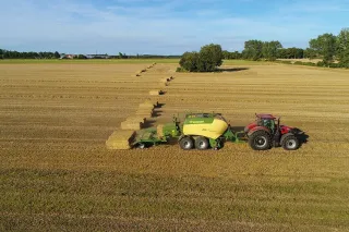Traktor s lisem Krone BaleCollect na poli
