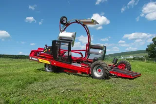 Červený balicí stroj Anderson Hybrid X na louce