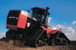 Červený pásový traktor Case IH Quadtrac na poli