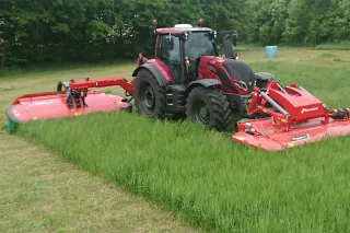 Traktor s žací kombinací Kverneland při sečení trávy