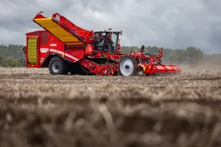 Červený samojízdný sklízeč Grimme Varitron 470 na poli