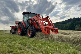 Traktor Kubota M4 s čelním nakladačem při práci se senem