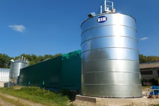 Kovové obilné silo BIN na zemědělském dvoře.