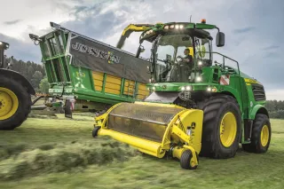 Zelená sklízecí řezačka John Deere při sklizni píce.