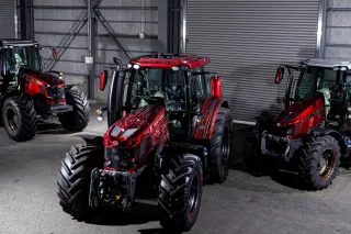 Tři červené traktory Massey Ferguson se speciálním lakem v hale.