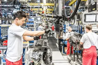 Pracovníci montují motory DEUTZ na výrobní lince.