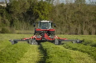 Traktor s žací kombinací Massey Ferguson seče louku.