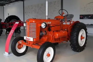 Historický oranžový traktor Zetor 25 vystavený v muzeu.