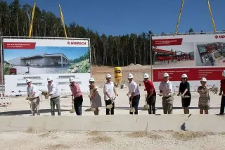Skupina lidí se symbolicky účastní zahájení stavby centra Horsch.