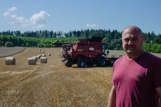 Zemědělec stojí na sklizeném poli před kombajnem Case IH.