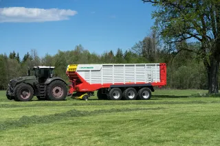 Traktor se senážním vozem Pöttinger na louce.