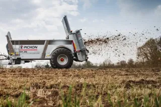 Rozmetadlo Pichon rozhazuje hnůj na poli.