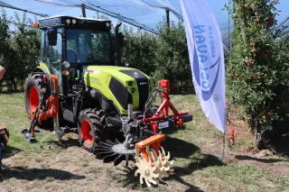 Traktor CLAAS NEXOS s nářadím pro práci v ovocném sadu.