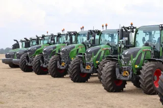 Řada zelených traktorů Fendt odstavených vedle sebe.