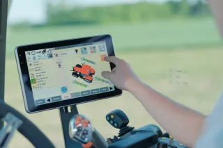 Ruka ovládá dotykový monitor v kabině traktoru Case IH.