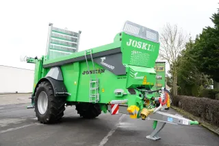 Zelené rozmetadlo hnoje Joskin Tornado na dvoře.
