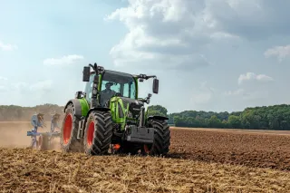 Zelený traktor Fendt při práci na poli.