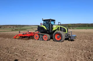 Pásový traktor Claas se strojem Väderstad na poli