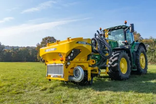 Žlutý čelní zásobník BEDNAR SEED BOX SB 1600 před traktorem.