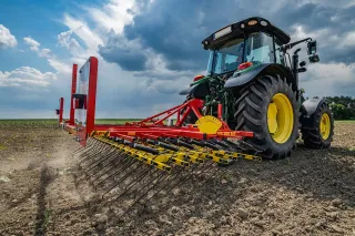 Traktor s polními branami APV na poli.