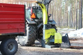 Štěpkovač Junkkari HJ 252 připojený k traktoru u lesa.