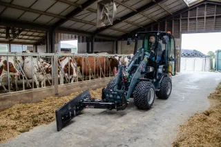 Elektrický nakladač TOBROCO-GIANT pracuje ve stáji s krávami.