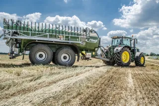 Traktor s cisternovým přívěsem Fliegl na poli.
