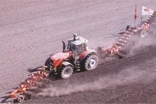 Traktor Massey Ferguson při rekordní orbě s dlouhou soupravou pluhů.
