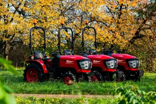 Tři červené malotraktory Zetor COMPAX v sadu.