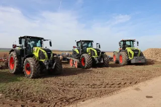Tři traktory CLAAS Xerion vystavené na poli.