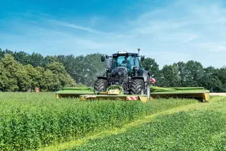 Traktor s žacím strojem Krone EasyCut při sečení píce.