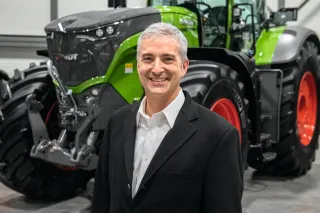 Eric Hansotia stojí před traktorem Fendt.