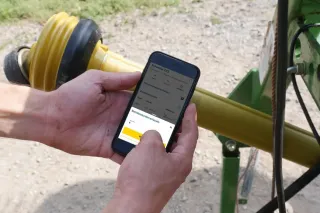 Ovládání aplikace Walterscheid na mobilním telefonu vedle kloubového hřídele.