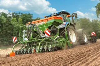 Zelený secí stroj Amazone při práci na poli
