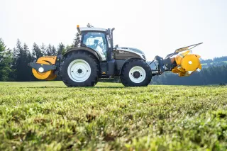 Traktor se žlutými silážními válci Mammut na louce.