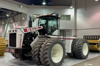Bílý kloubový traktor Big Bud ve výstavní hale.