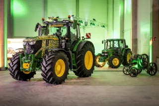 Jubilejní traktor John Deere vystavený v hale.