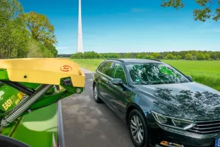 Kamerový systém na žacím stroji Krone vedle automobilu.