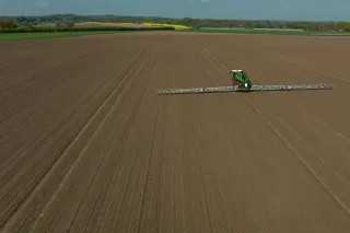 Samojízdný postřikovač na rozlehlém poli z ptačí perspektivy