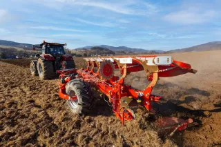 Červený pluh OPaLL-AGRI ORION II za traktorem na poli