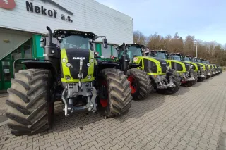 Řada traktorů Claas před budovou zemědělského podniku