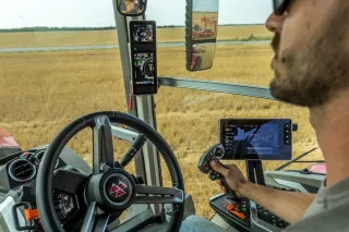 Řidič v kabině traktoru Massey Ferguson s naváděcím systémem