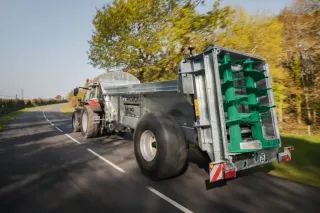 Traktor s rozmetadlem Pichon na silnici