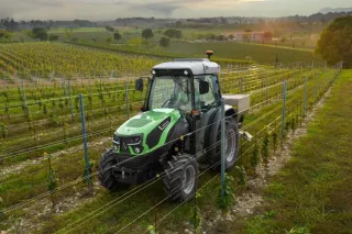 Zelený traktor Deutz-Fahr mezi řádky vinice