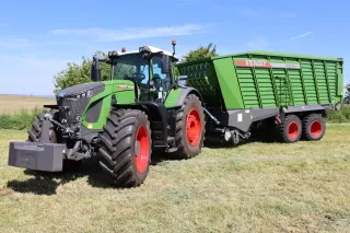 Traktor Fendt se zeleným sběracím vozem na louce